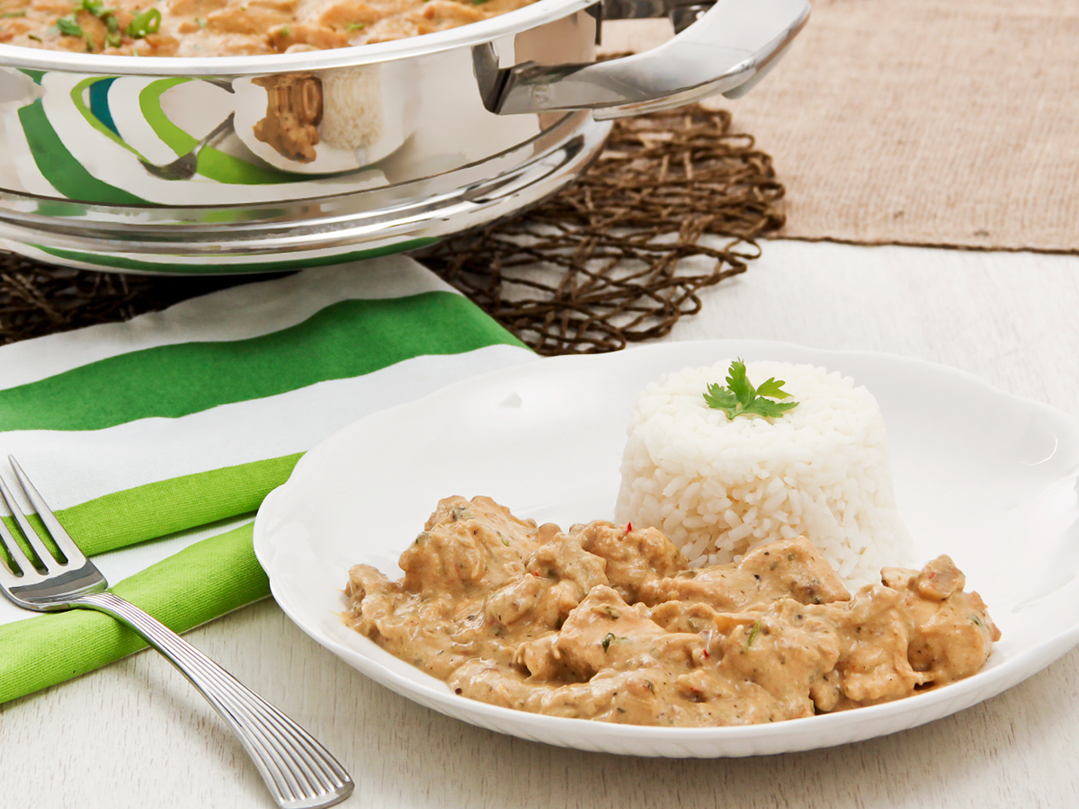 Nutty chicken casserole on white plate with rice